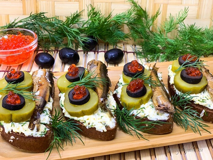 Бутерброды со шпротами, маринованным огурцом и красной икрой на черном хлебе